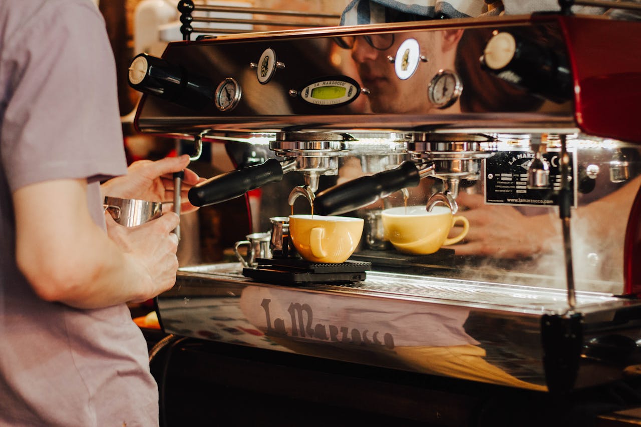 digital-01 Barista using espresso machine to brew coffee in a café, showcasing coffee preparation process.